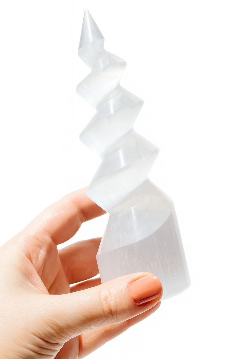 Hand holding a white, spiral-shaped object against a white background